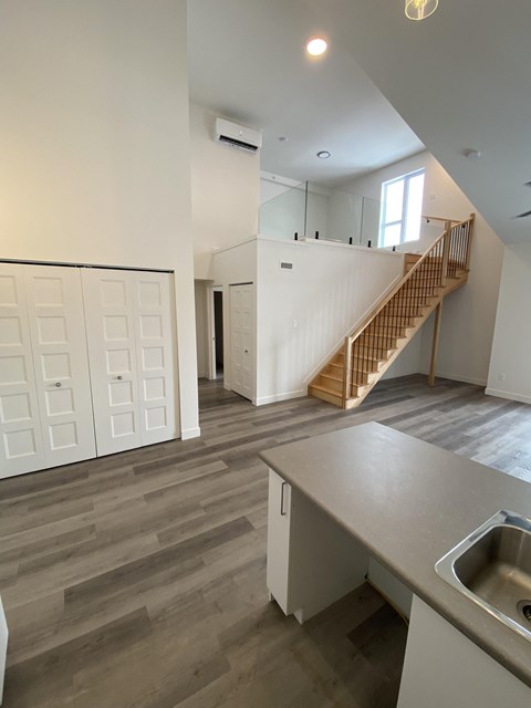 A kitchen with a sink and a staircase.