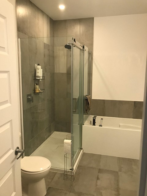 A white toilet is in a bathroom with a glass shower door.