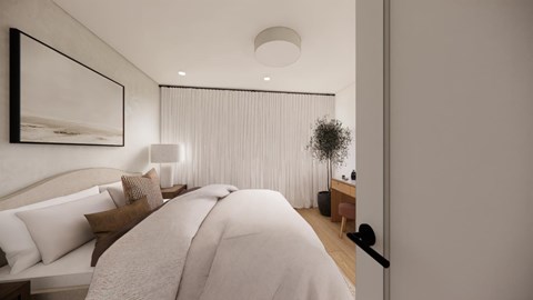 A bedroom with a large bed and a painting on the wall.