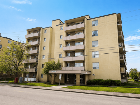 A large apartment building with balconies and multiple windows.