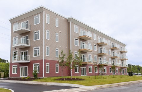 A large apartment building with multiple balconies and windows.