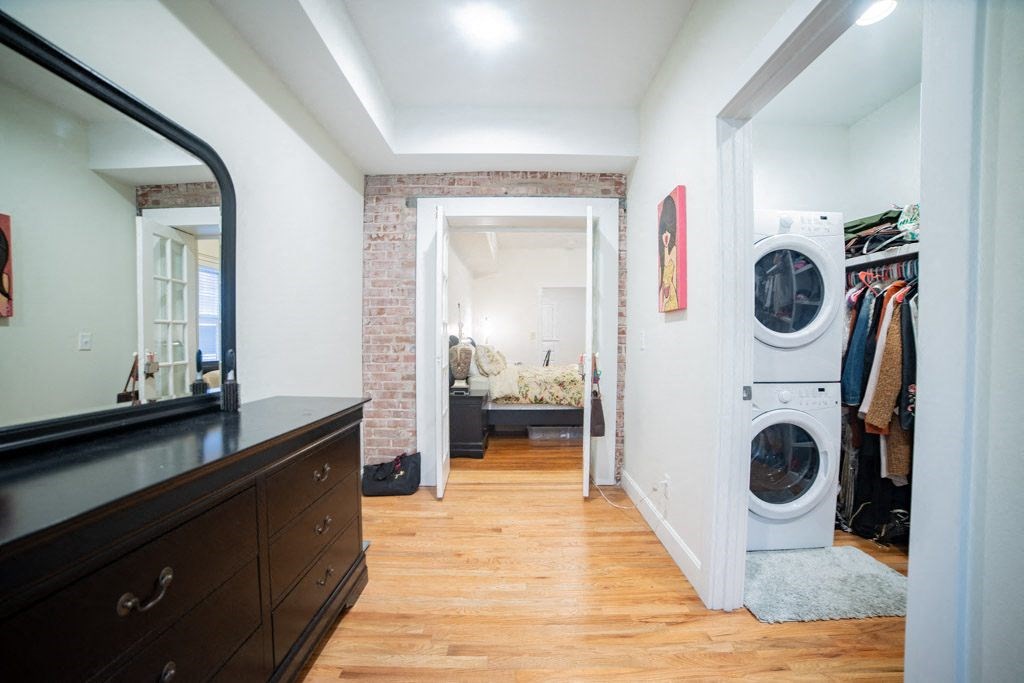 a room with a washer and dryer in it and a closet with a dresser