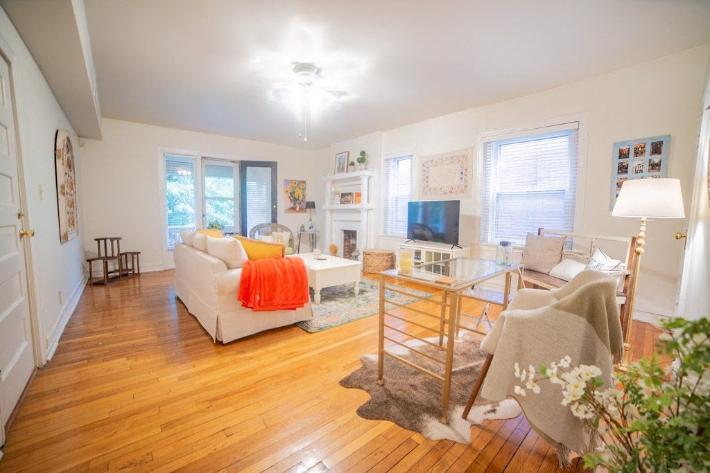 a living room with white walls and hardwood floors