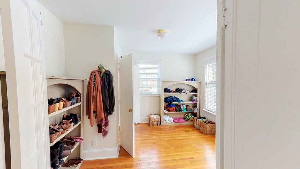 a room with a closet and shelves filled with clothes and shoes