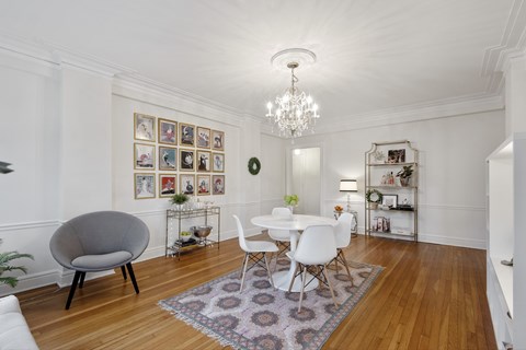 A white dining room with a round table and chairs.