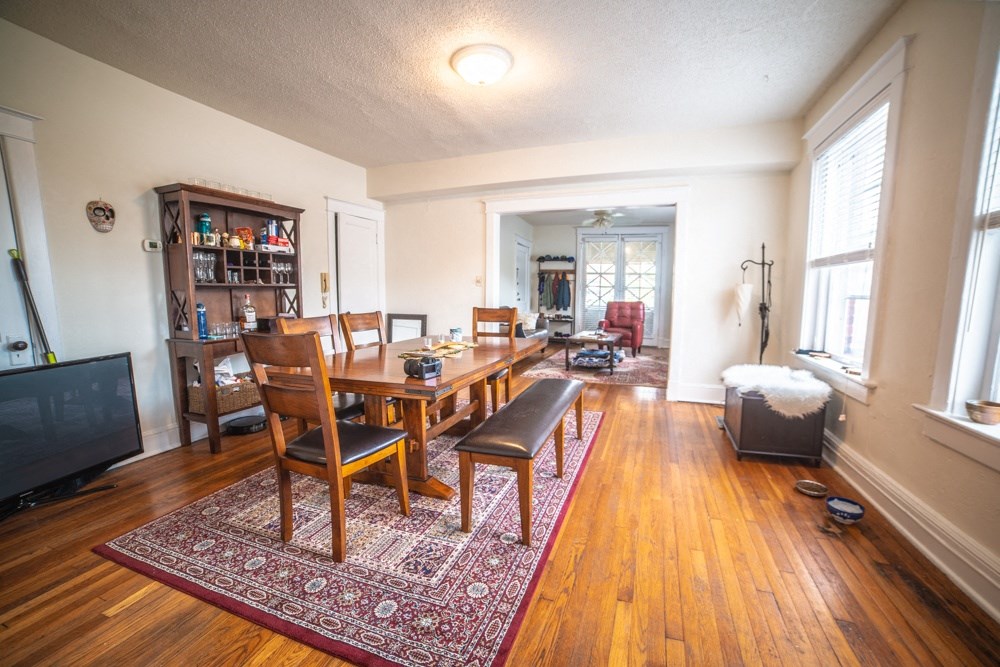 a dining room and living room with a wooden table and chairs
