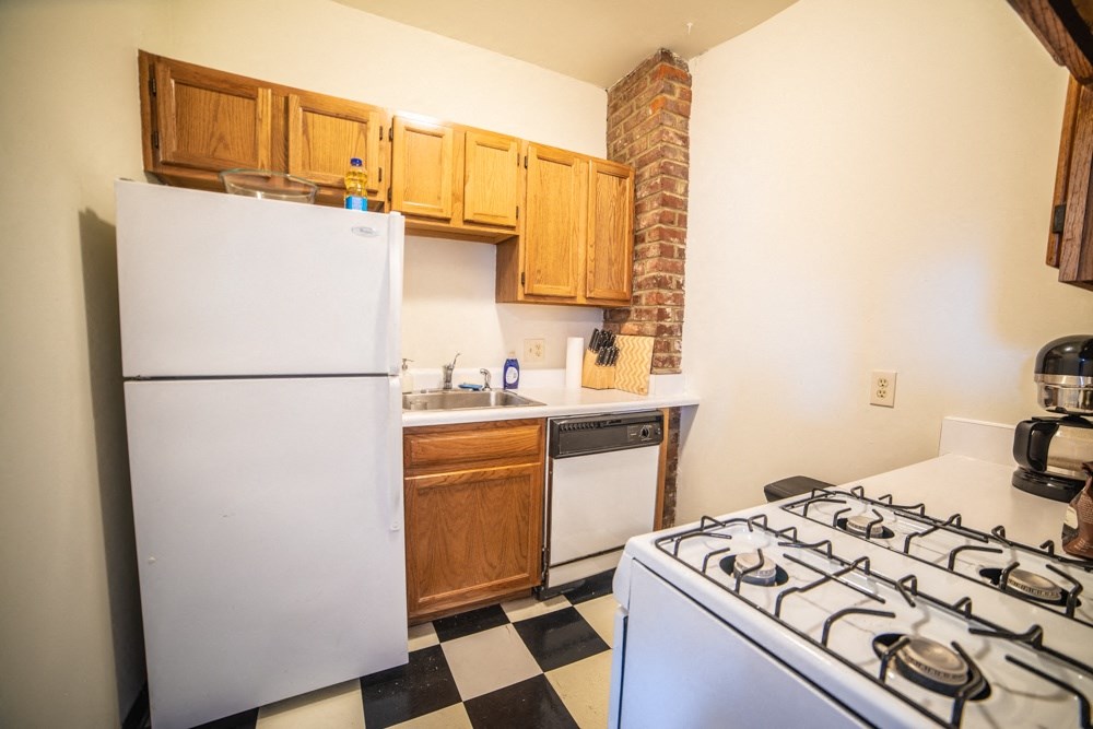 a kitchen with a stove and refrigerator and a sink