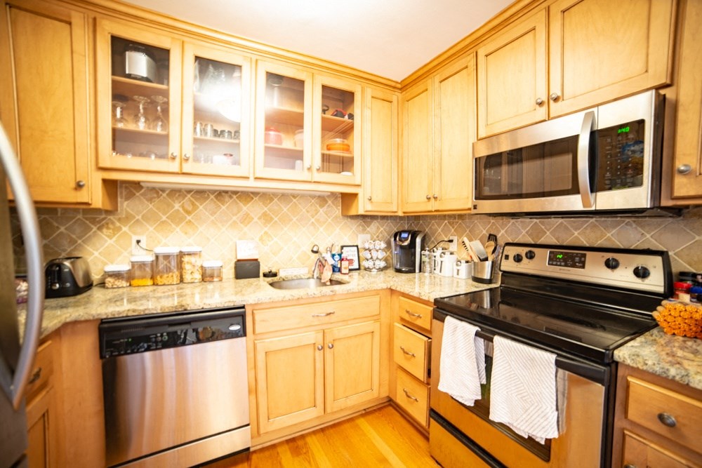 a kitchen with wooden cabinets and stainless steel appliances
