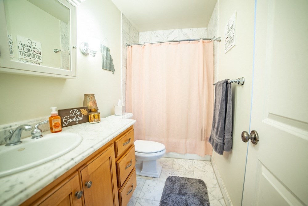 a bathroom with a shower and a sink and a toilet