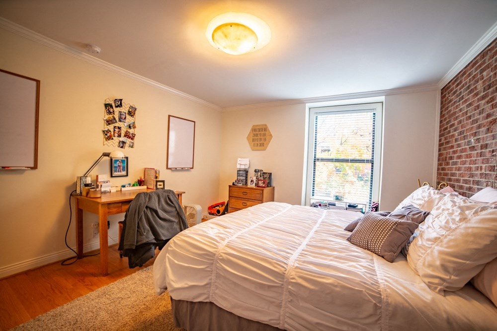 a bedroom with a bed and a desk and a window
