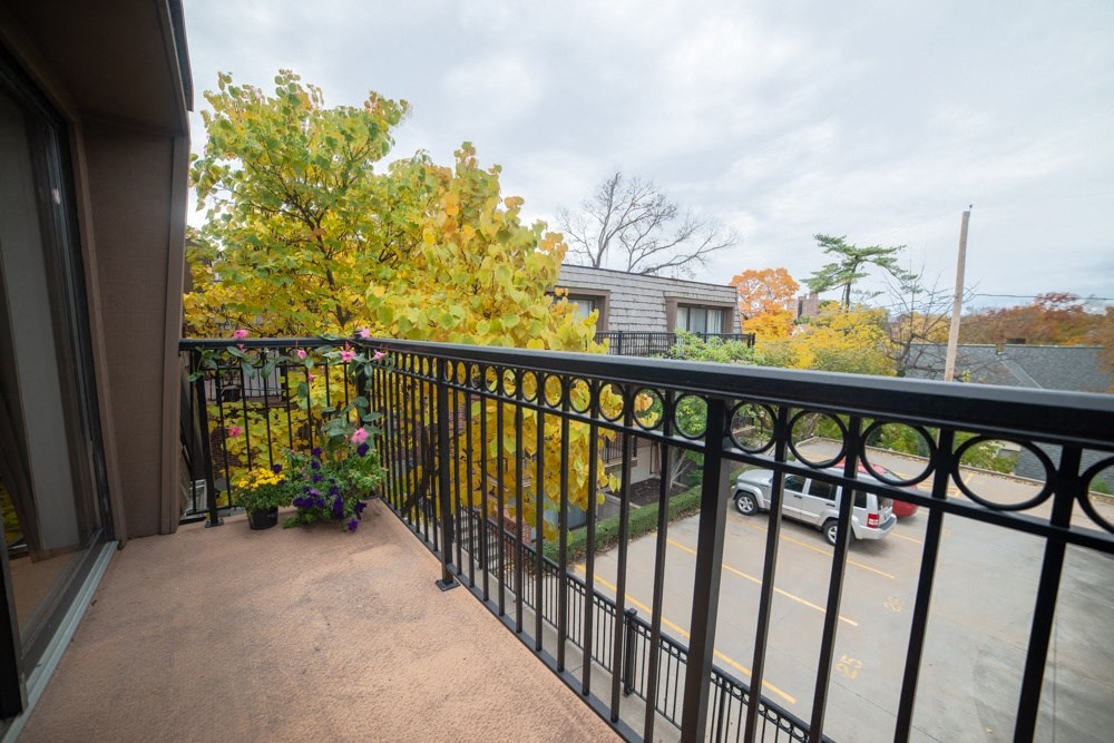 a balcony with a black railing and a parking lot