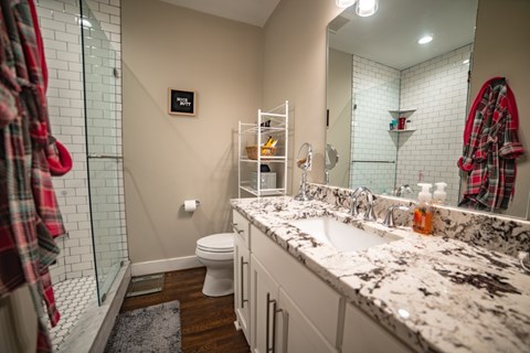 A bathroom with a white toilet, a sink, and a mirror.