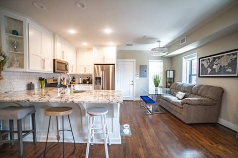 A kitchen with a bar area and a couch in the living room.