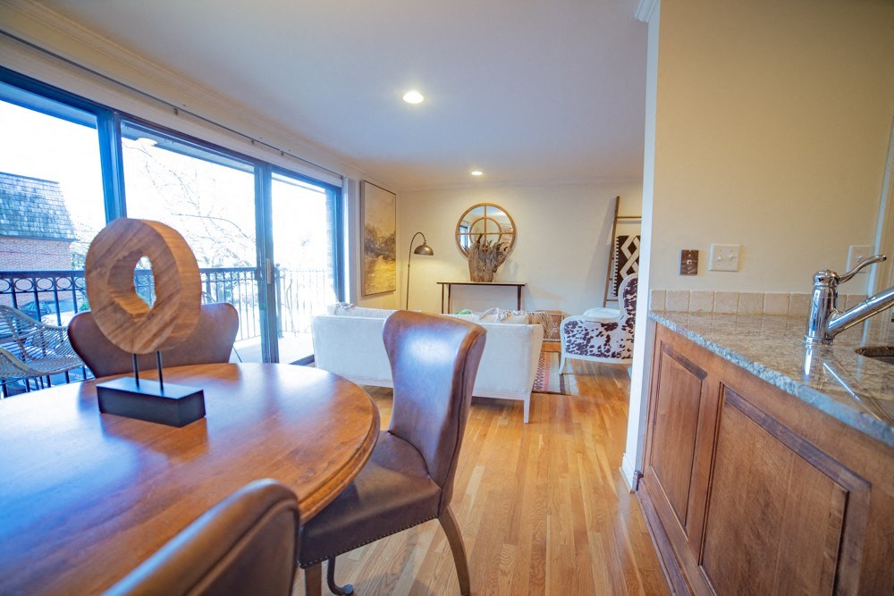 a dining room and living room with a wooden table and chairs