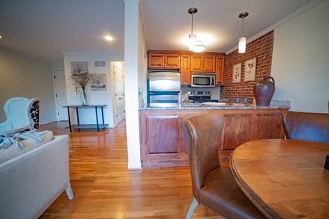 A kitchen with a table and chairs in the foreground and a refrigerator in the background.