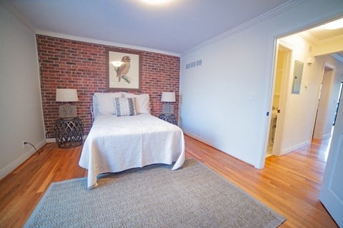 a bedroom with a bed and a brick wall