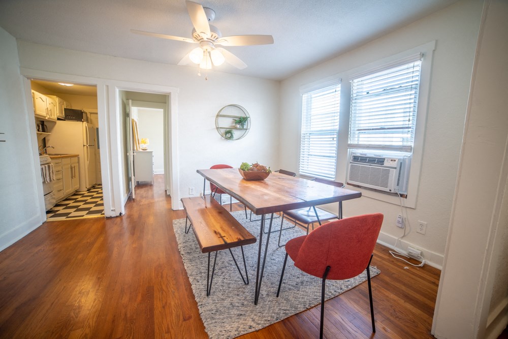an empty living room with a dining room table and chairs