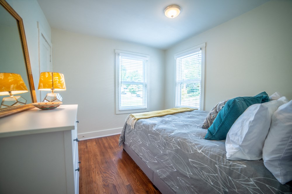 a bedroom with a bed and two windows