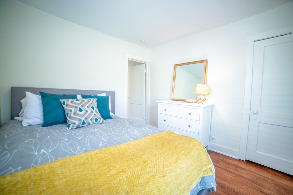 a bedroom with a bed and a dresser with a mirror