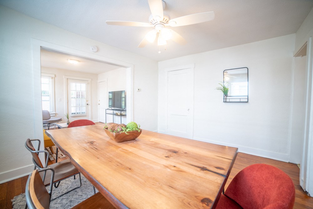 a dining room with a wooden table and chairs and a ceiling fan
