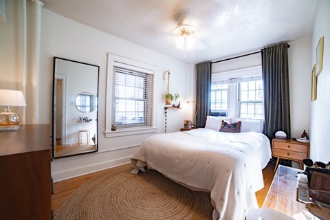 A bedroom with a large bed and a mirror on the wall.