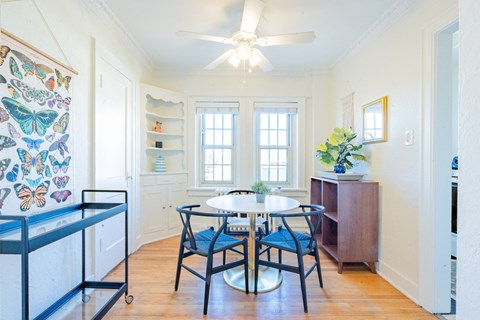 A dining room with a table and chairs.