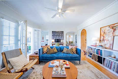 A living room with a blue couch and a wooden coffee table.