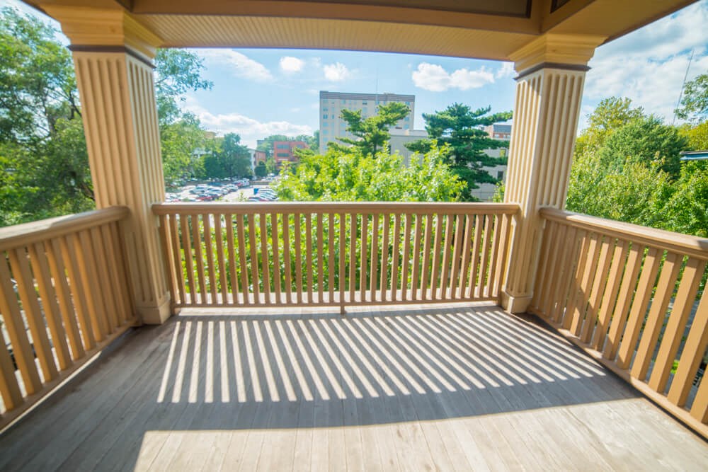 a covered porch with a view of the city