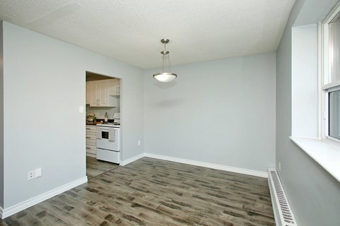 A room with a wooden floor and a window on the right side.