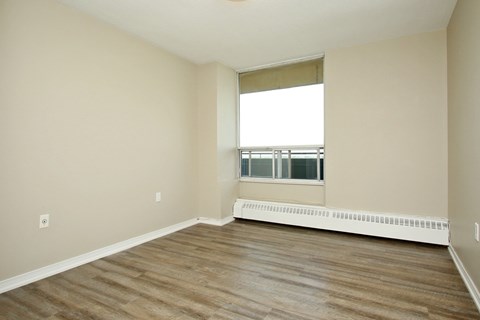 A room with wooden flooring and a window.