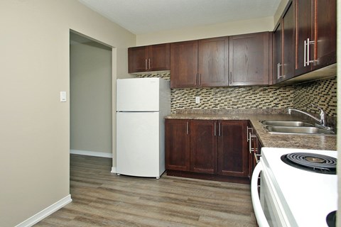 A kitchen with a white fridge and wooden cabinets.