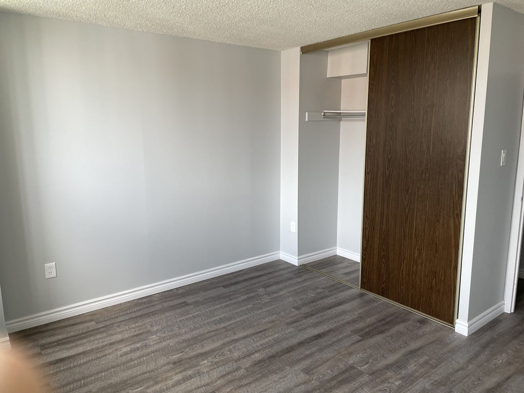 an empty room with a closet and a wood floor