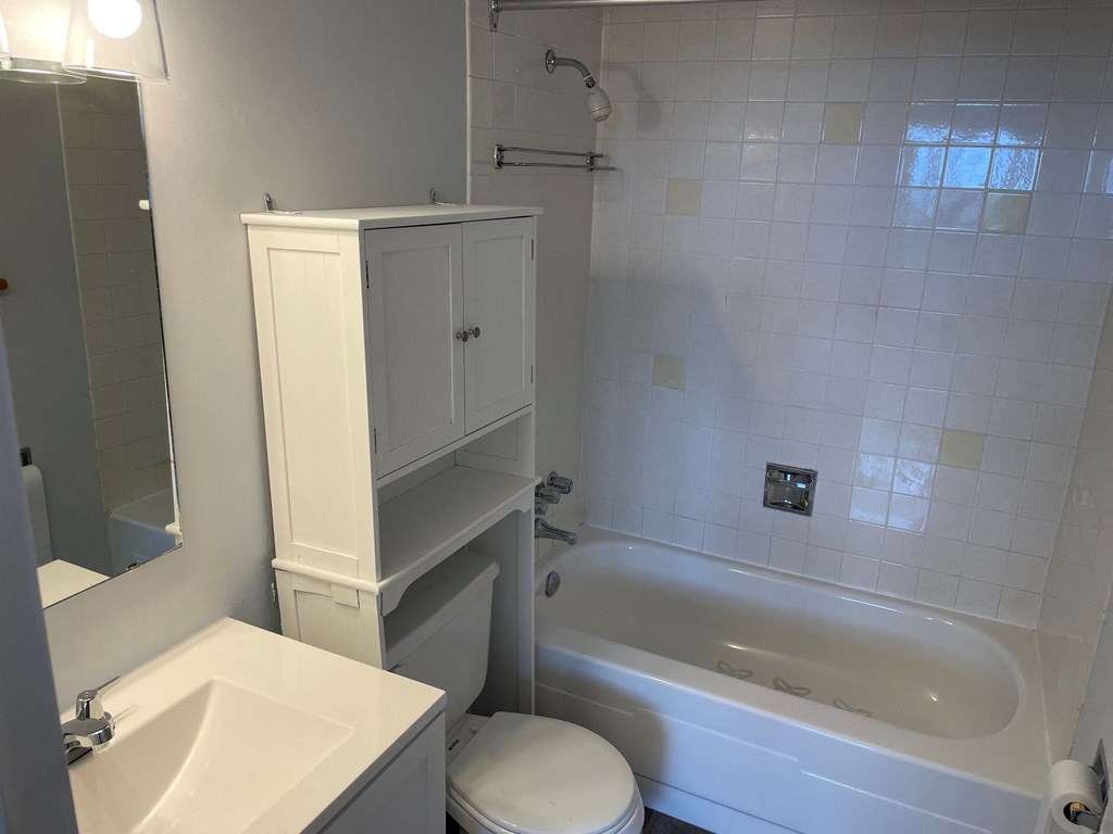 A white bathroom with a toilet, sink, and bathtub.
