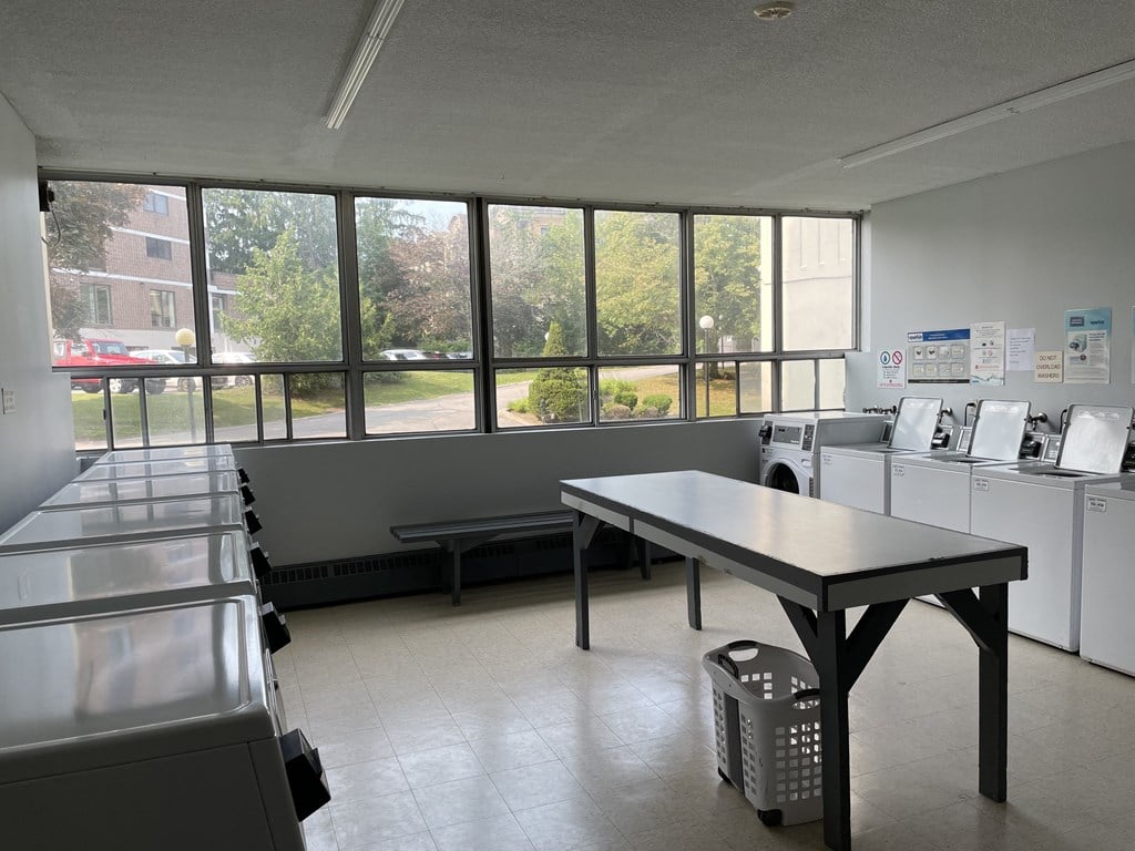 a kitchen with a table and washes and dryers in a room with windows