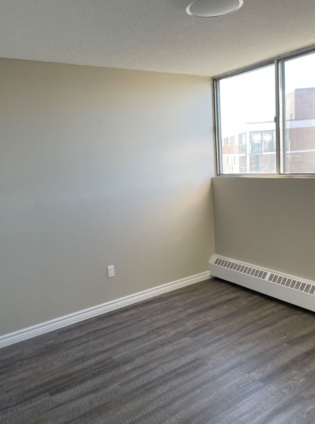 A room with a window and a radiator on the wall.