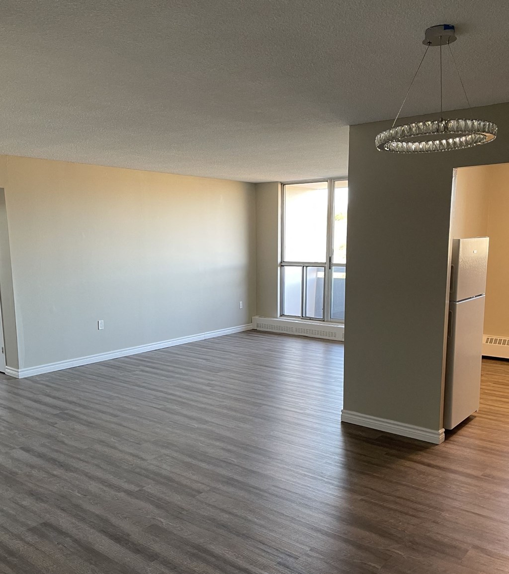 A room with a grey floor and a white wall with a window.