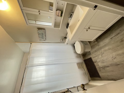 A white ceiling with a vent and a light fixture.