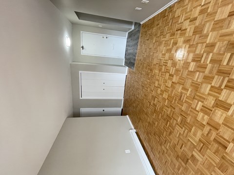 A room with a wooden wall and a white door.