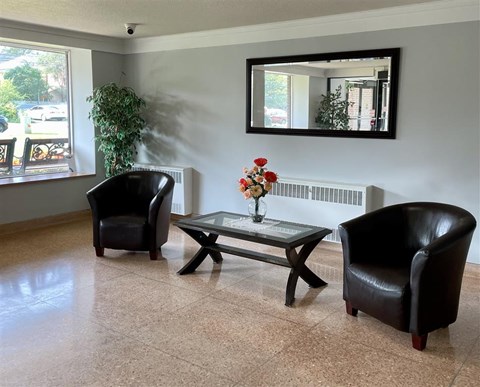 a living room with two black chairs and a table