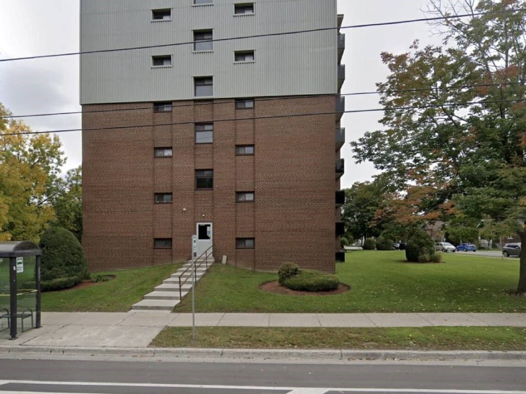 an apartment building on the corner of a sidewalk
