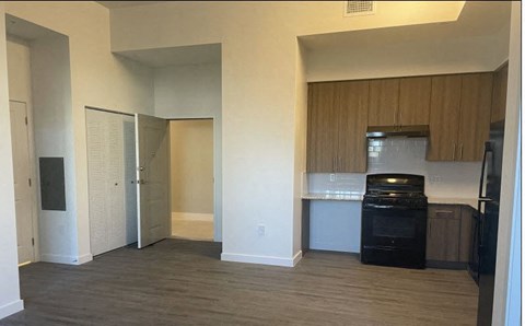 A kitchen area with a black oven and wooden cabinets.