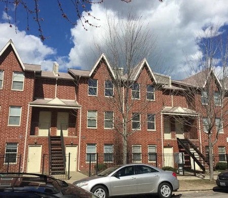 a car parked in front of a brick apartment building
