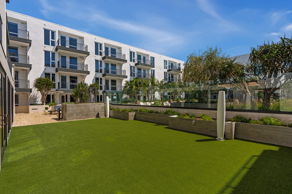 A grassy area in front of apartment buildings.