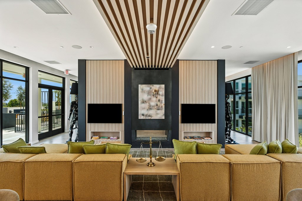 A modern living room with a fireplace and a large painting above it.