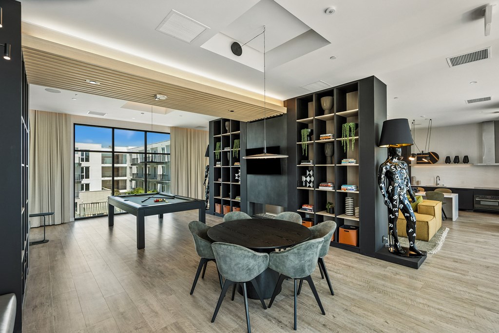 A modern living room with a pool table and a view of the outside.