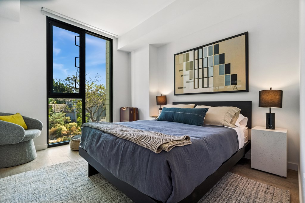 A bedroom with a large bed and a painting on the wall.