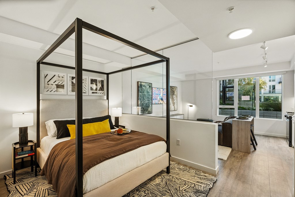 A bedroom with a four poster bed and a desk.