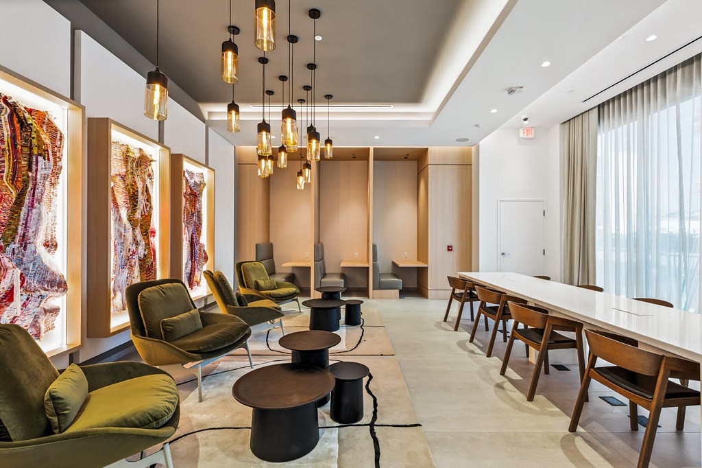 A room with a long table and chairs with a hat on the floor.