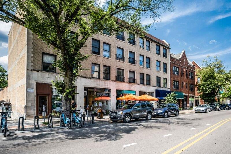 A street view of a building with a bicycle rack in front of it.