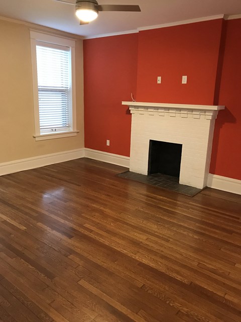 a living room with a fireplace and wooden floors